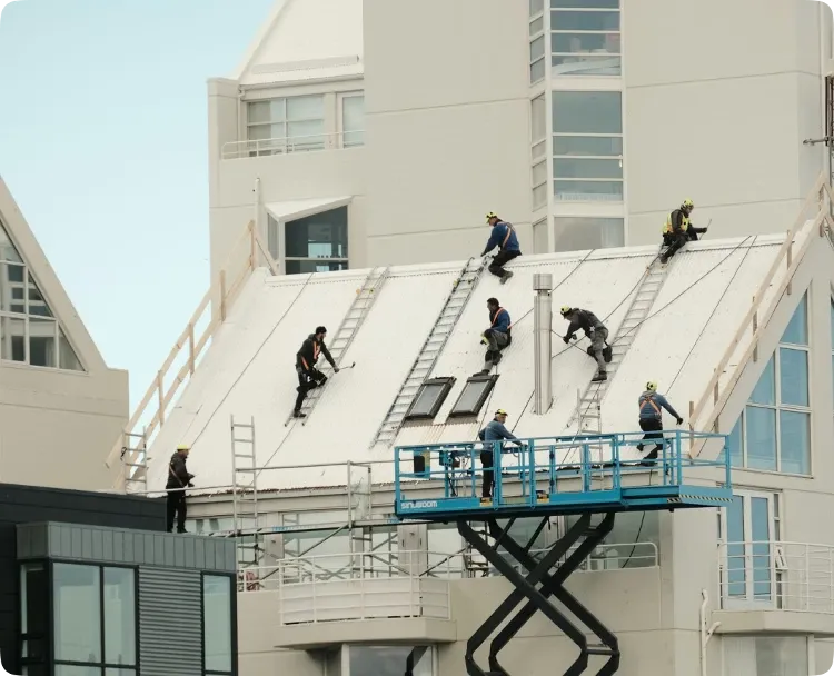 Commercial roofing crew working on a multi-story building