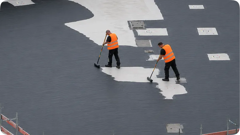Commercial waterproofing crew on large flat roof